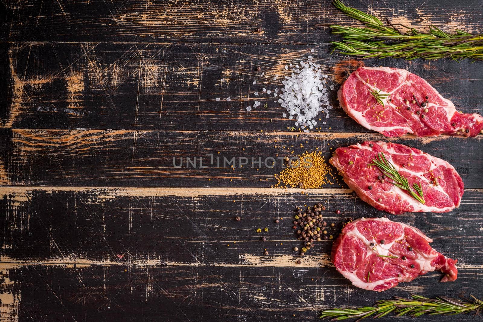 Raw juicy meat steak on dark wooden background