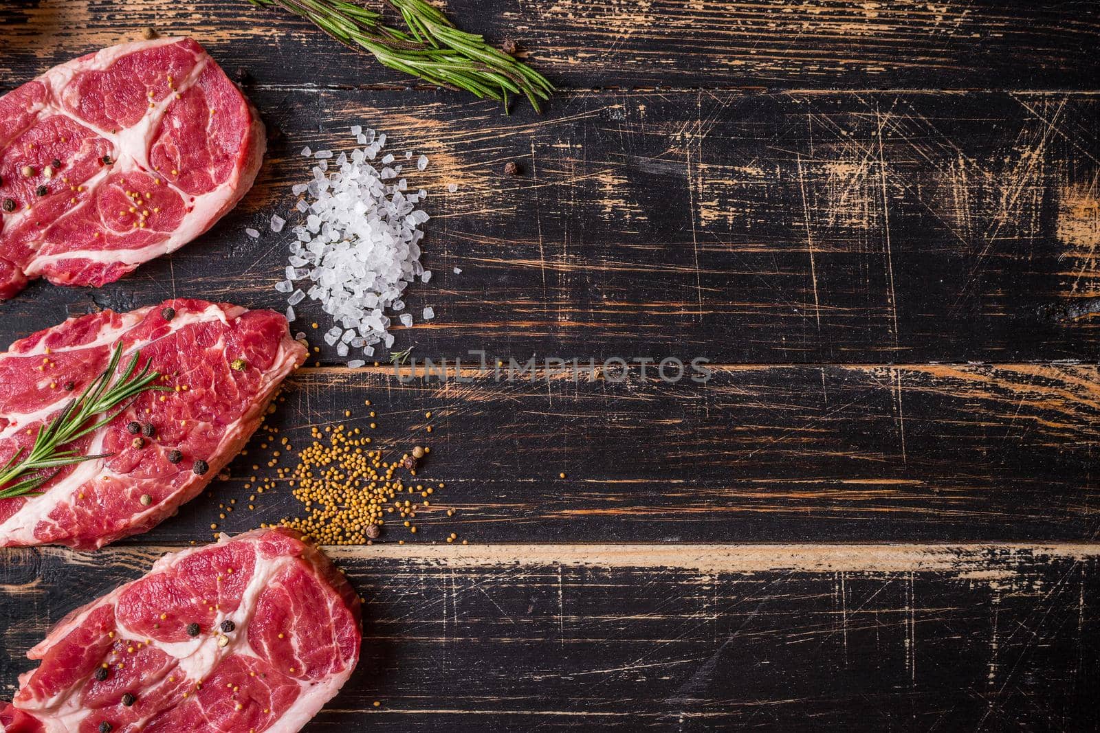 Raw meat steak on dark wooden background ready to roasting by its_al_dente