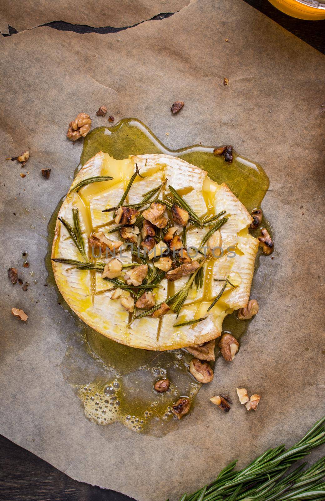 Delicious beautiful baked camembert with honey, walnuts, herbs and pears