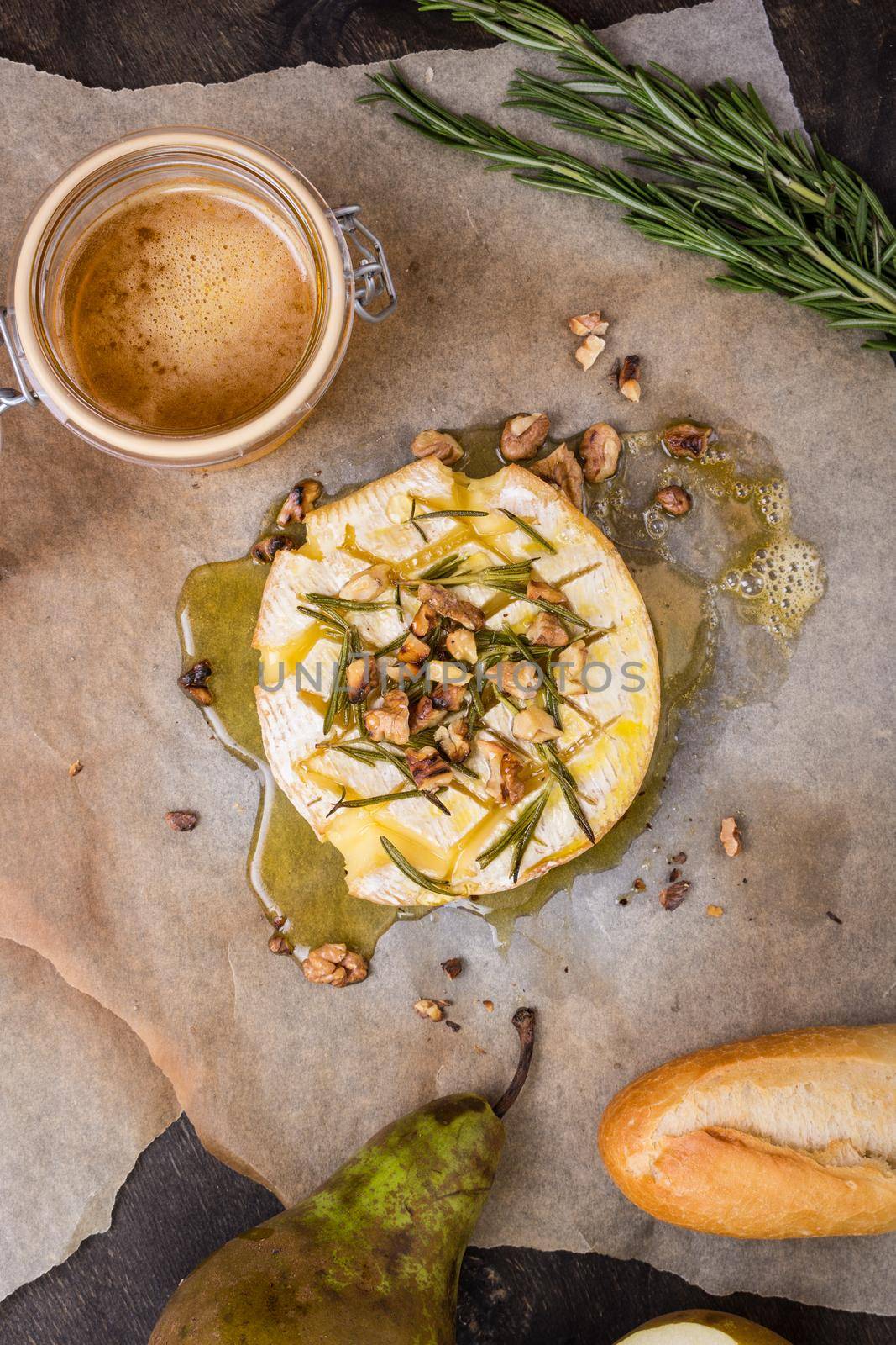 Delicious beautiful baked camembert with honey, walnuts, herbs and pears