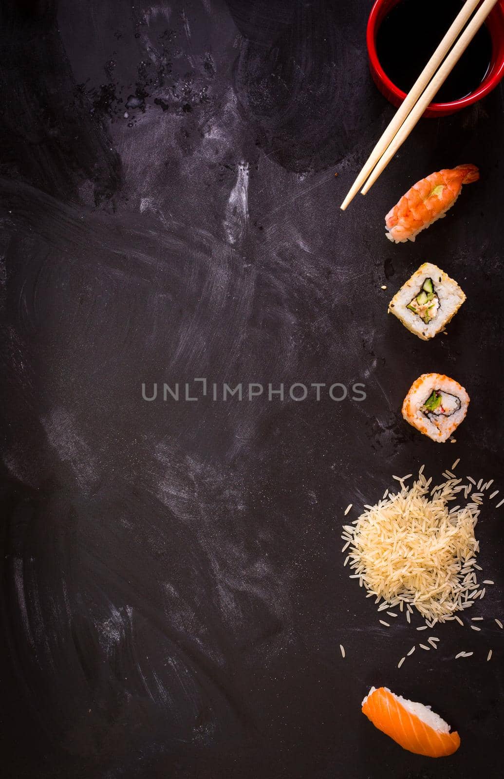Overhead shot of sushi on dark background. Sushi rolls, nigiri, rice, soy sauce, сhopsticks. Asian food background. Space for text. Sushi set....