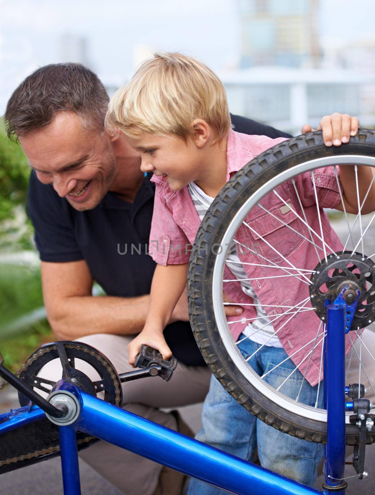 A handsome father showing his son the different parts of a bike.