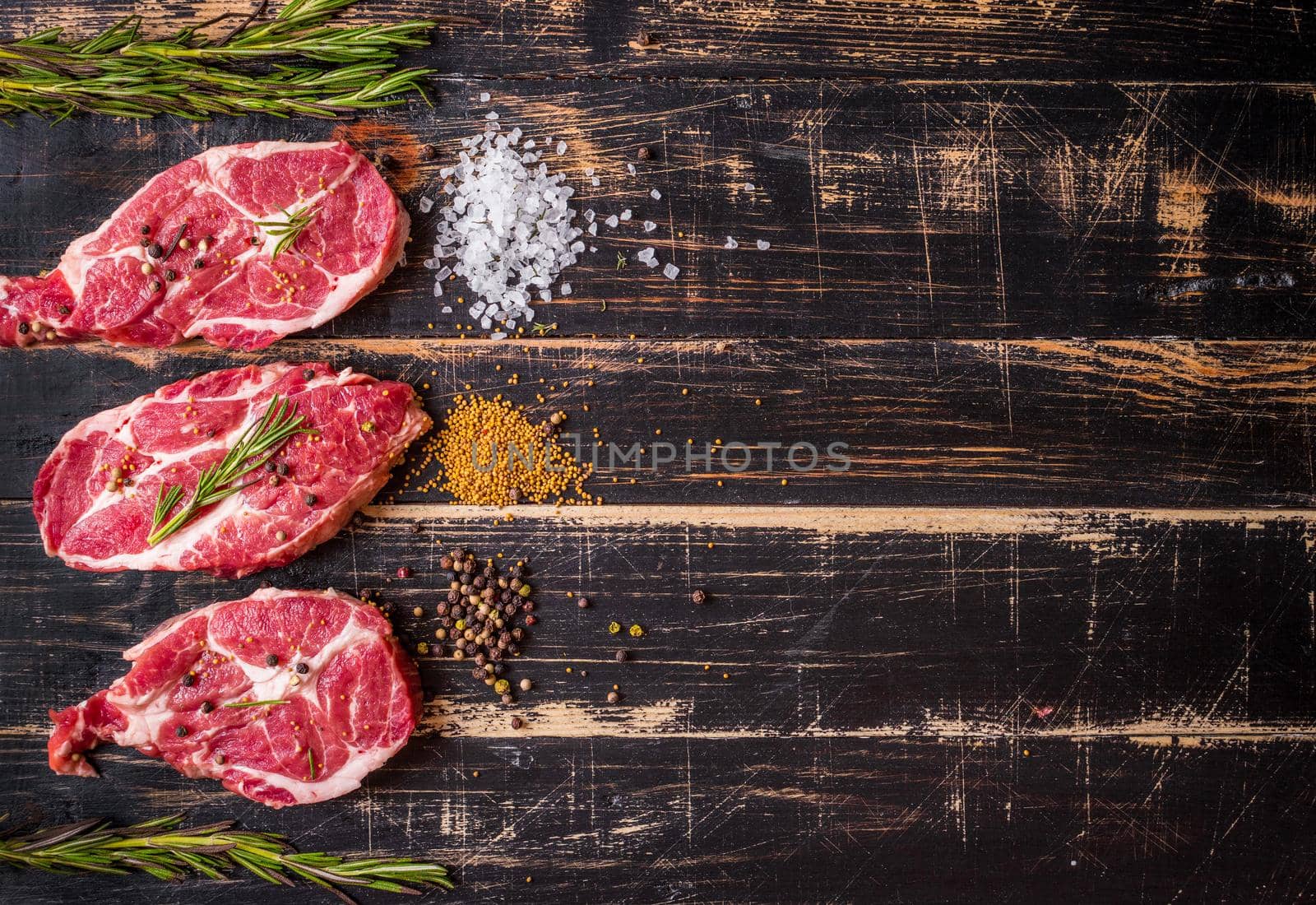 Raw meat steak on dark wooden background ready to roasting by its_al_dente