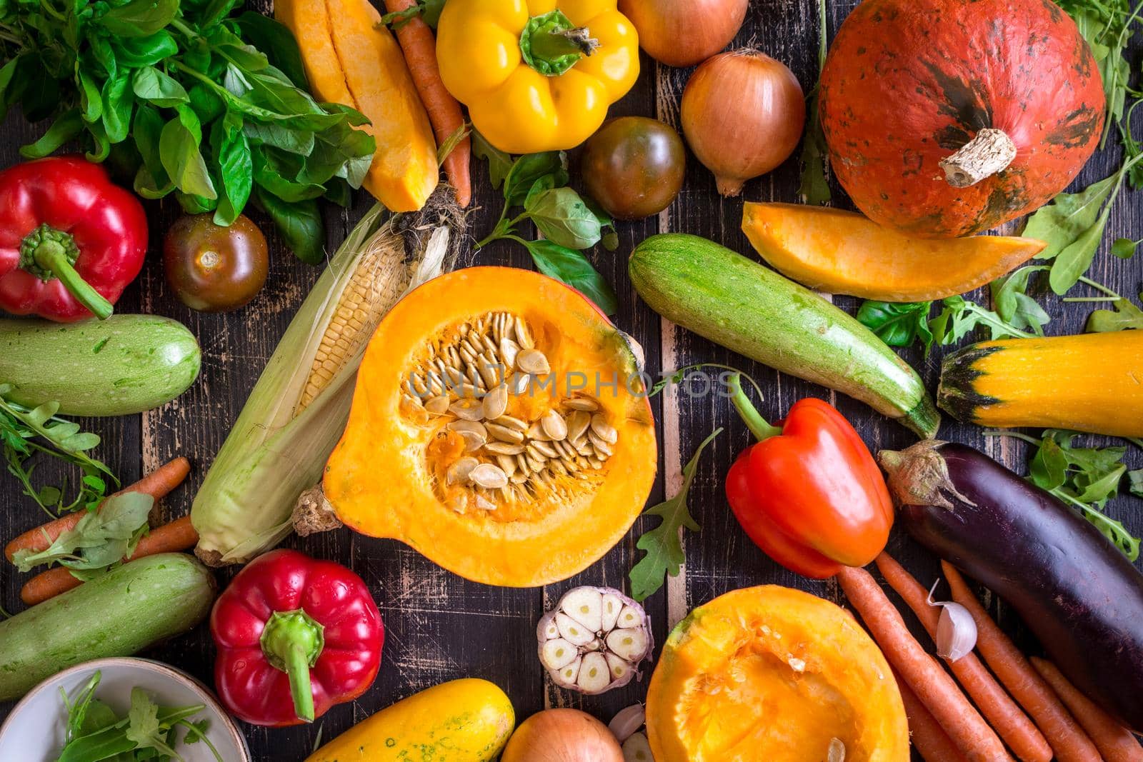 Fresh vegetables scaterred on a rustic dark textured table. Autumn background by its_al_dente