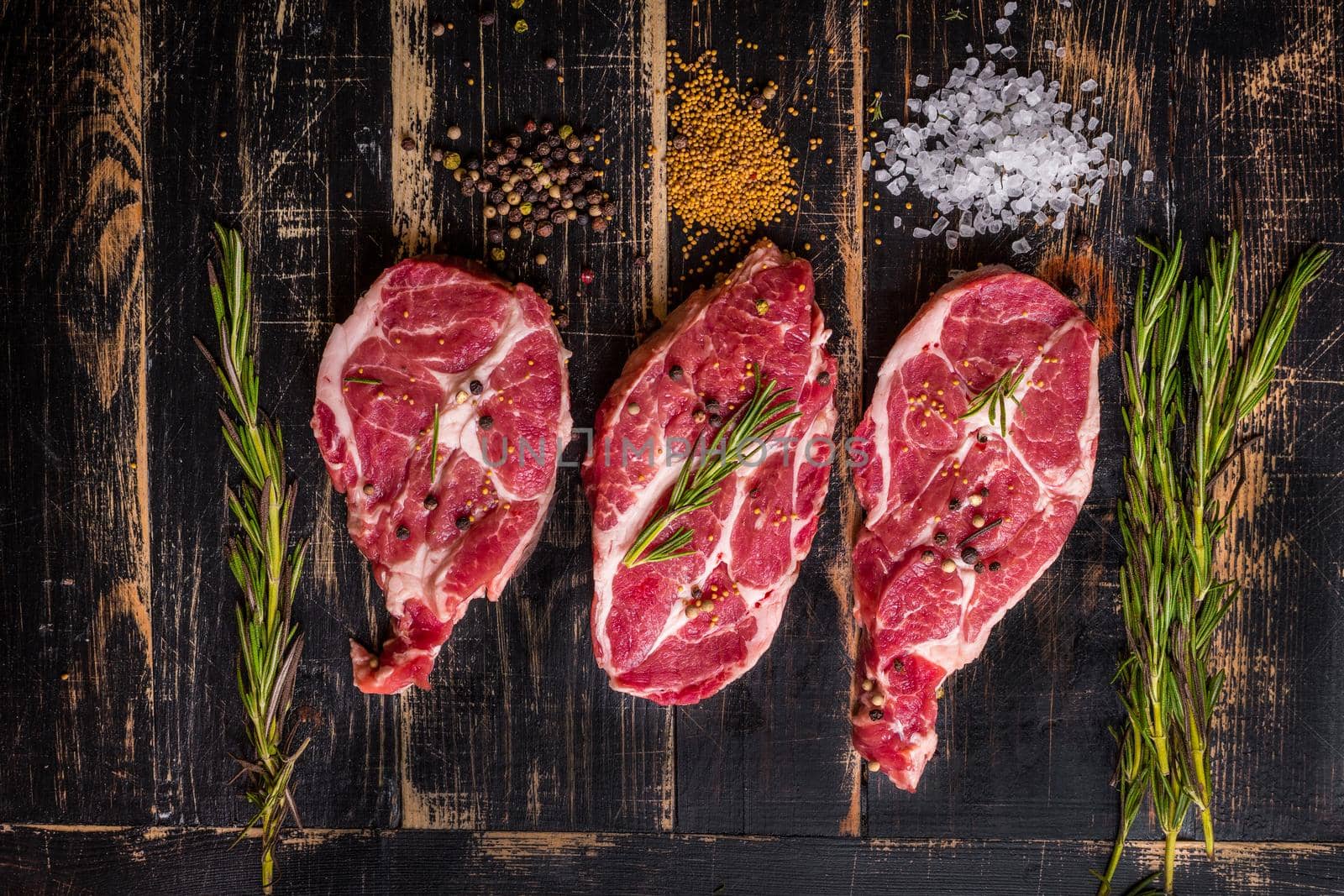 Raw juicy meat steak on dark wooden background