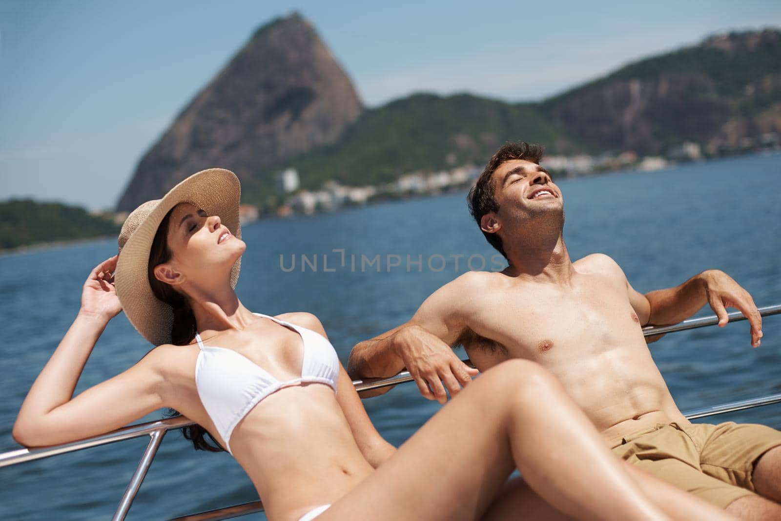 Its just them and the open ocean. Shot of an attractive young couple relaxing on a yacht together. by YuriArcurs