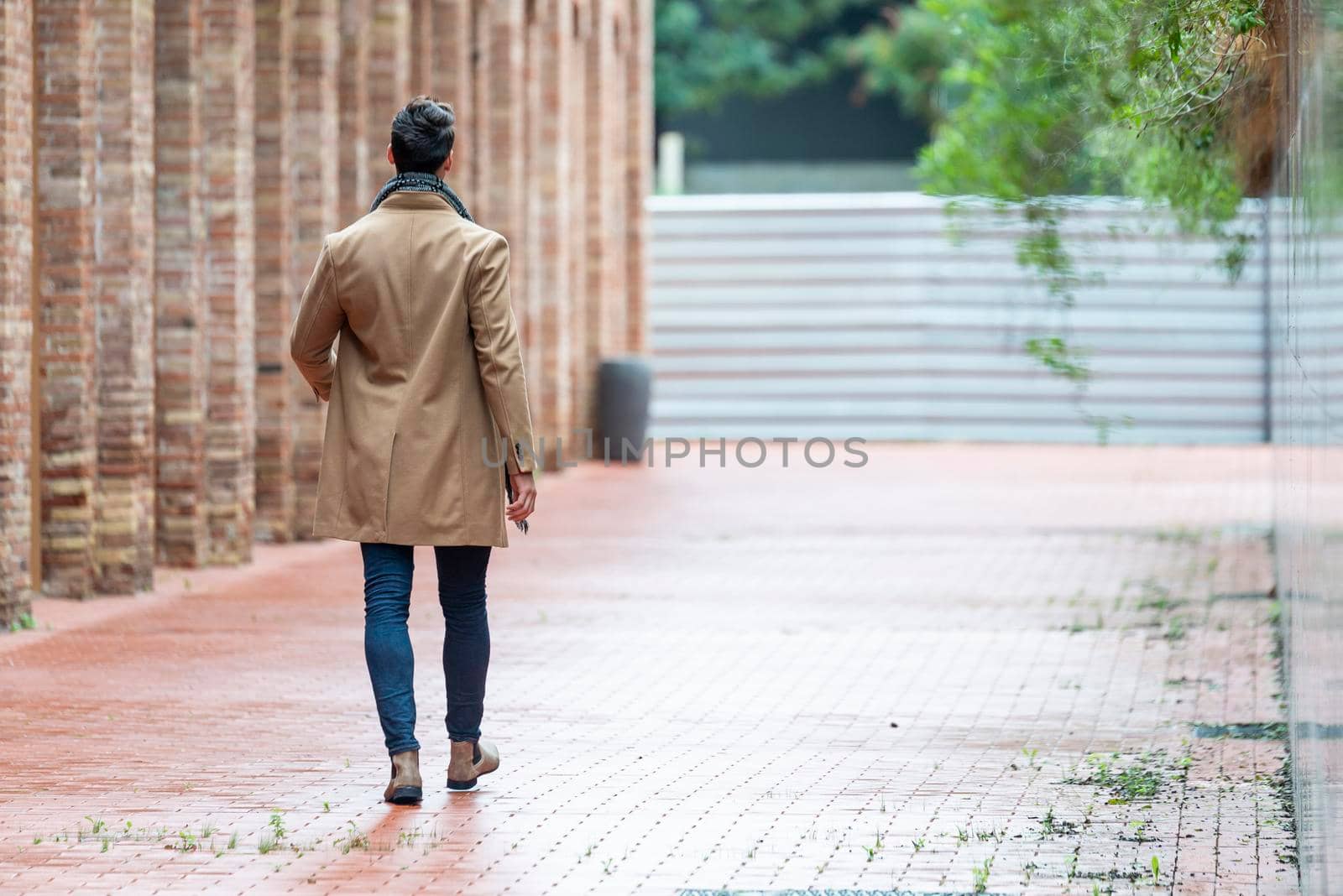 Handsome young man wearing winter clothes walking on the city. Street photo concept.