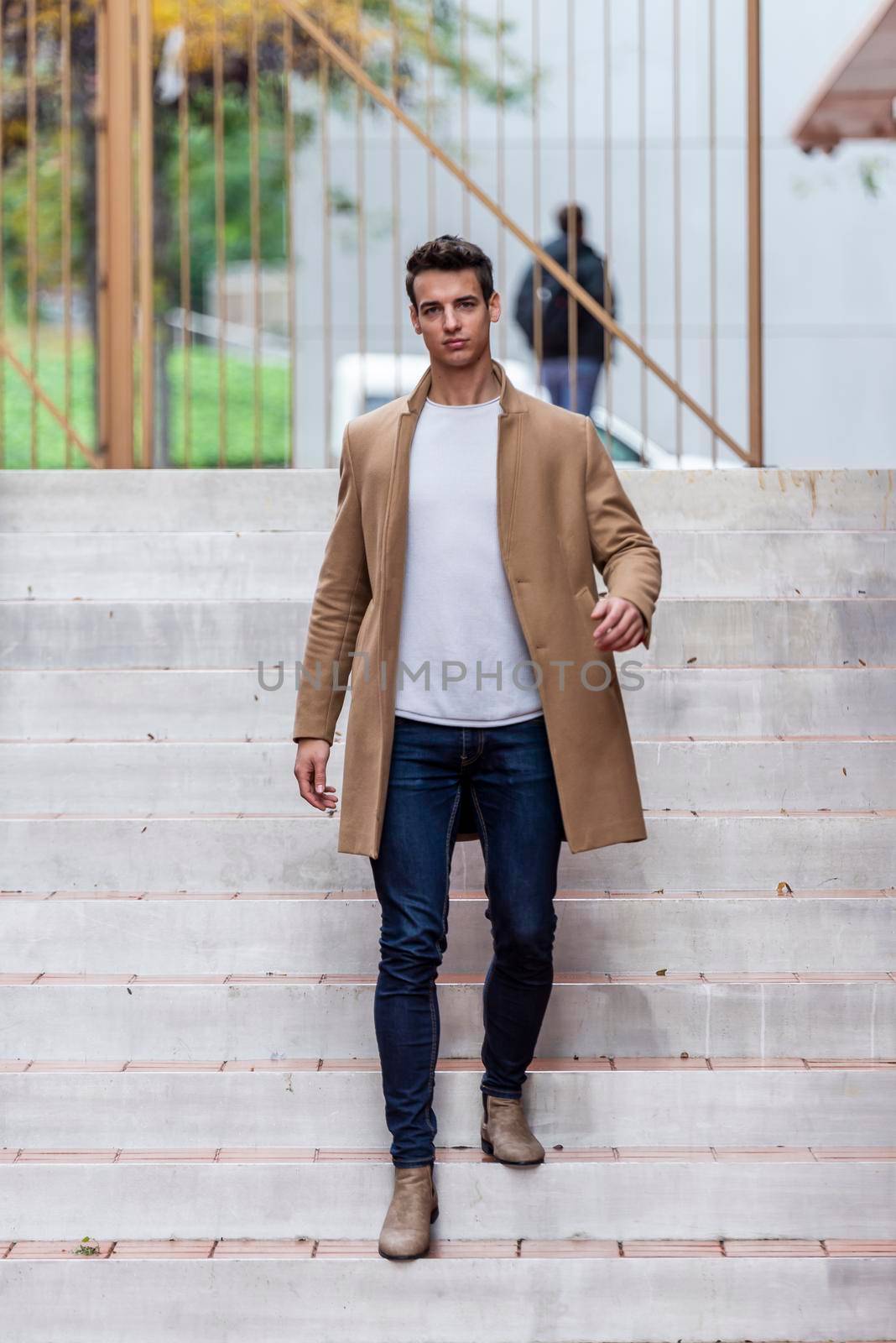 Young man outdoor in winter fashion, wearing woolen jacket in city setting