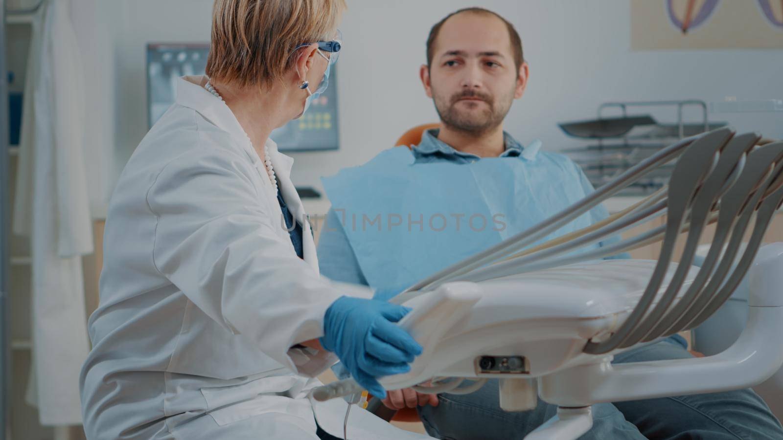 Mature dentist examining patient with caries and toothache, getting ready to do dental inspection with stomatological tools and instruments. Specialist doing oral care procedure.