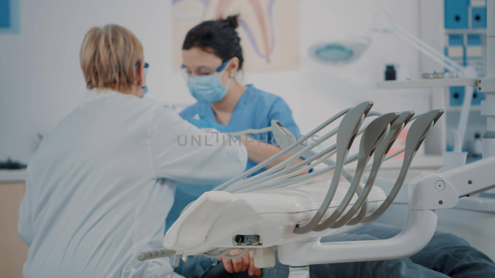 Dentistry team examining patient in stomatology cabinet by DCStudio