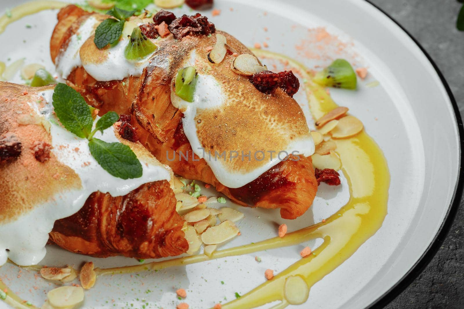 croissant with sweet cream and almonds on a plate. Delicious and healthy breakfast.