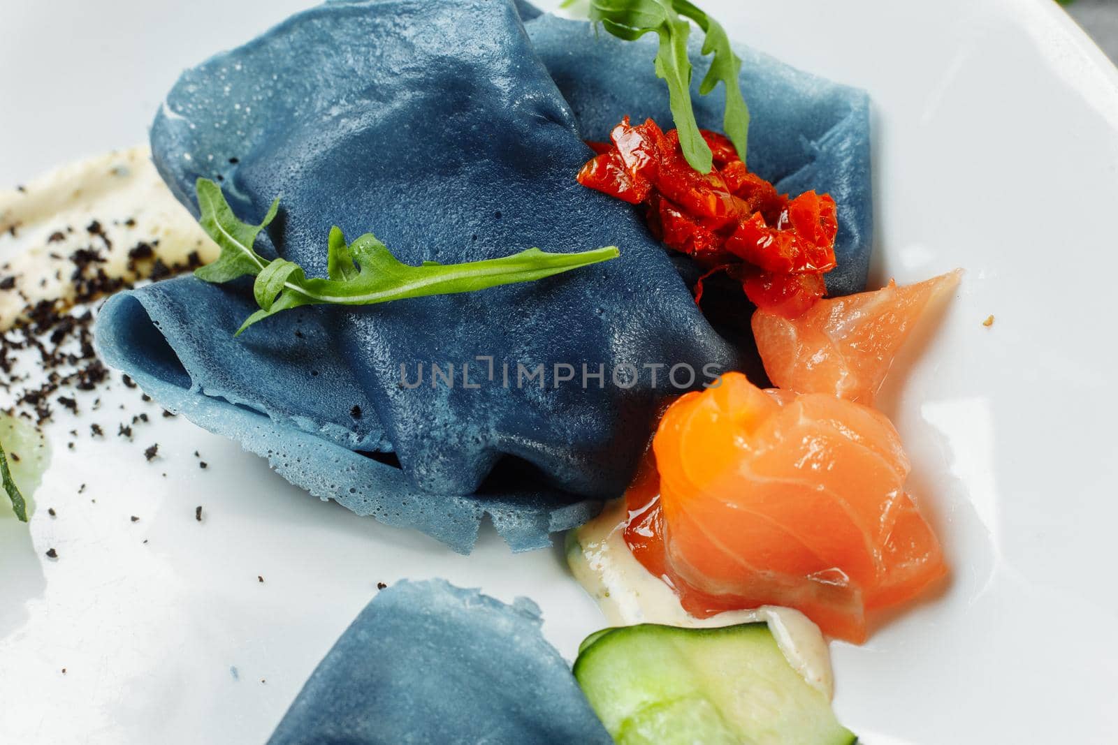 a stack of pancakes with salted salmon on a plate. Blue pancakes with salmon. Useful breakfast by UcheaD