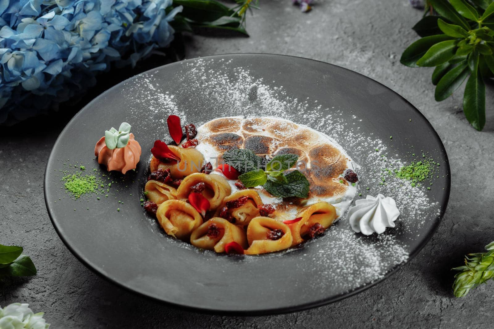Pancakes with cheese in orange sauce served with caramelized nuts and almonds. Appetizing dish. Culinary photography, a proposal to serve a meal.