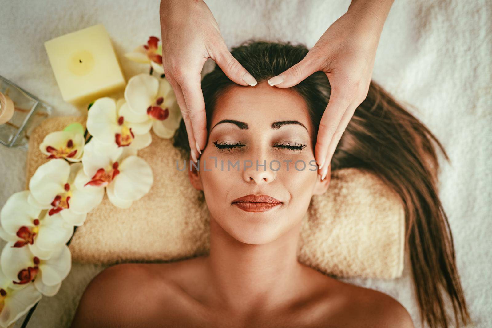 Cute young woman enjoying in head massage with her eyes closed.