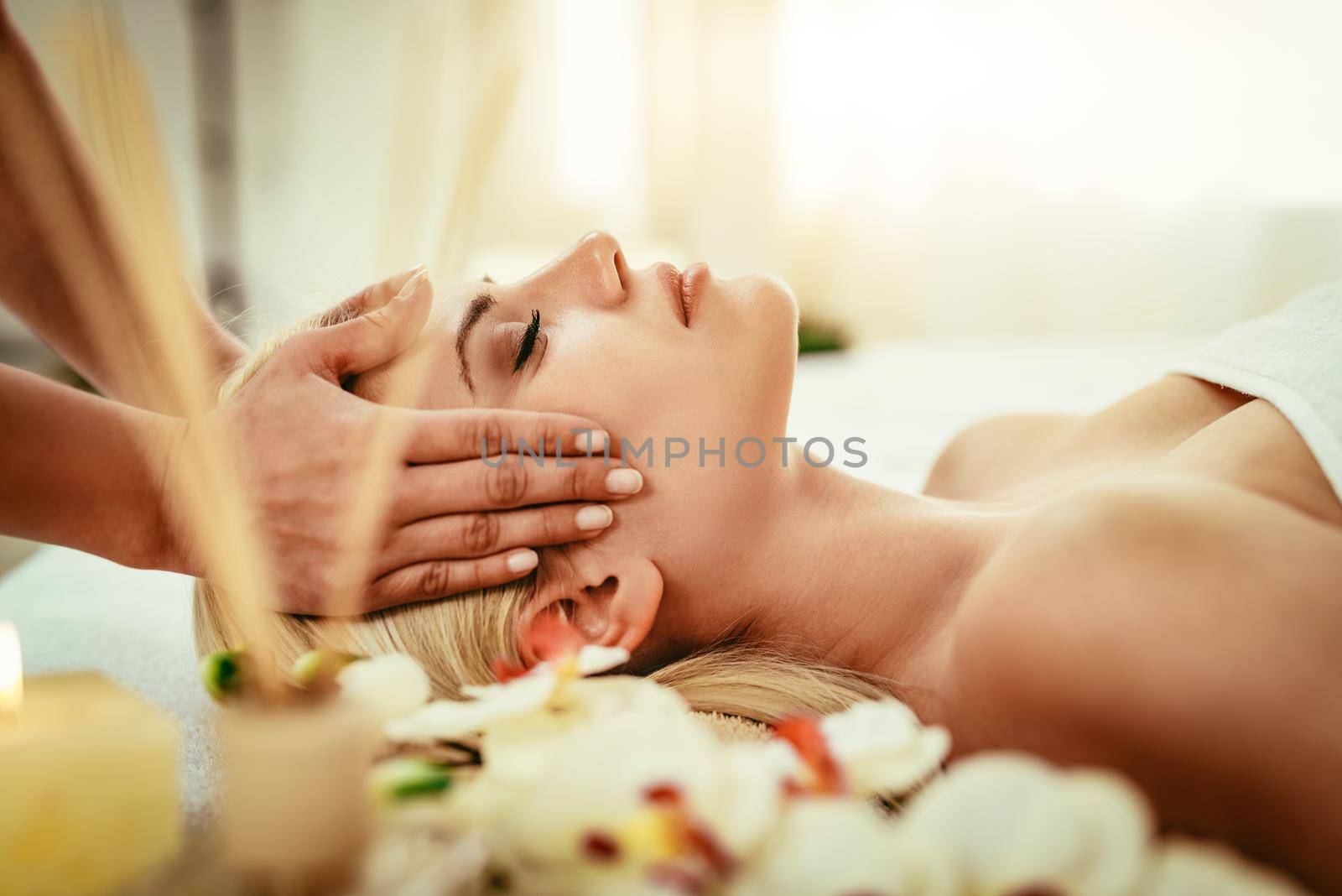 Cute young woman enjoying in head massage with her eyes closed.