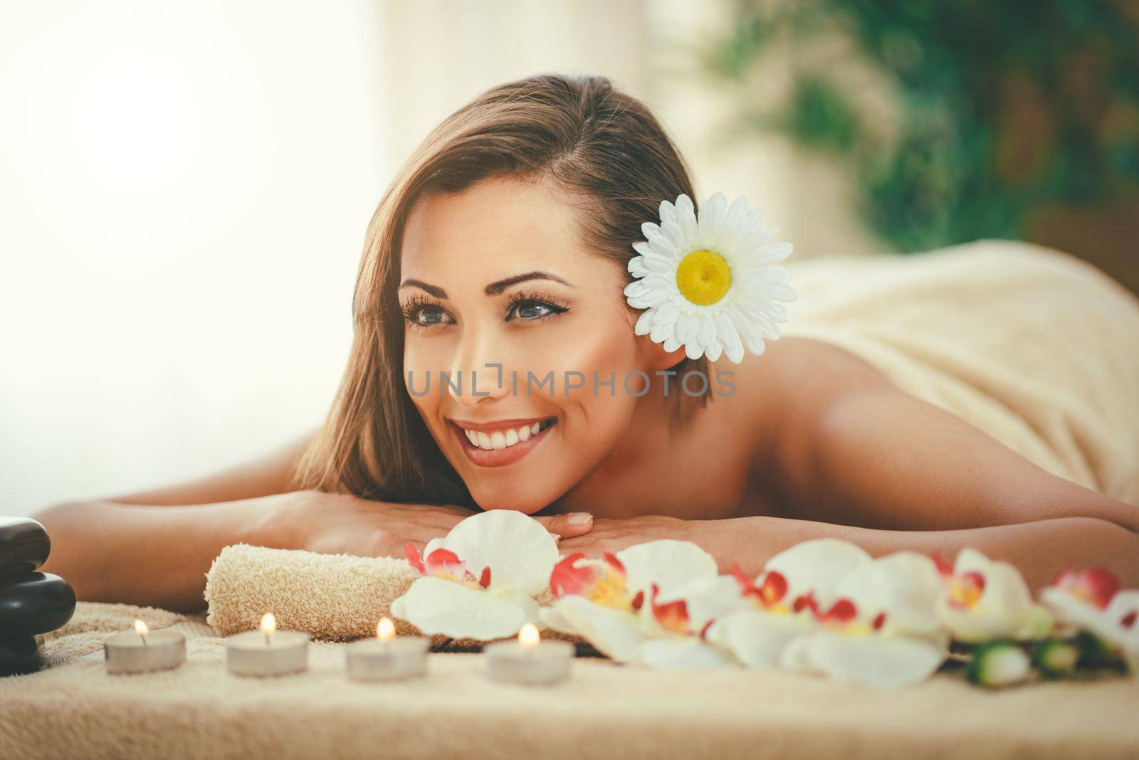 Cute young woman is enjoying during a skin care treatment at a spa. 