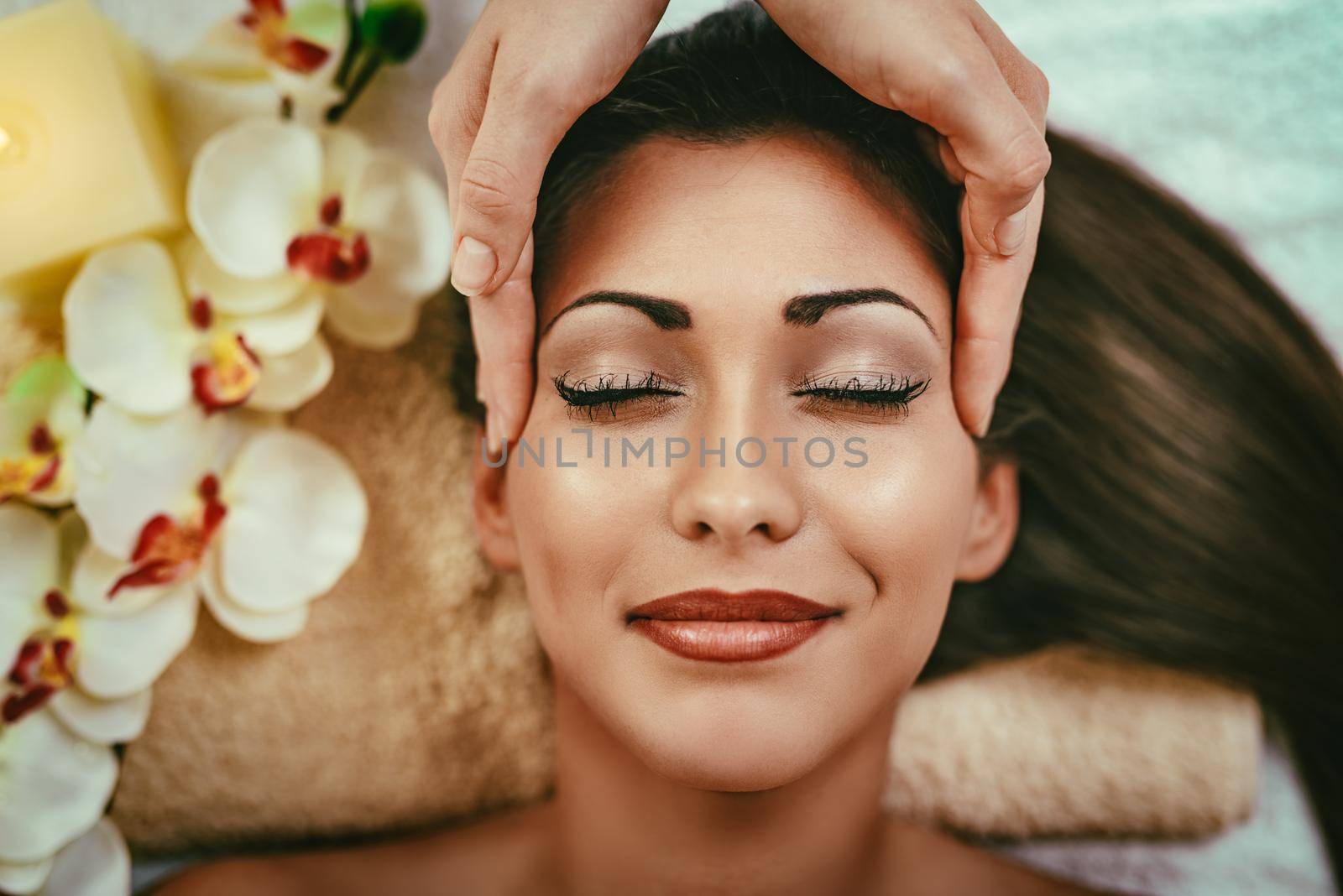 Cute young woman enjoying in head massage with her eyes closed.