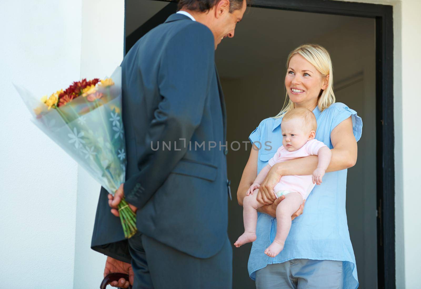 Hes coming home with flowers. Cropped shot of a man surprising his wife with flowers. by YuriArcurs