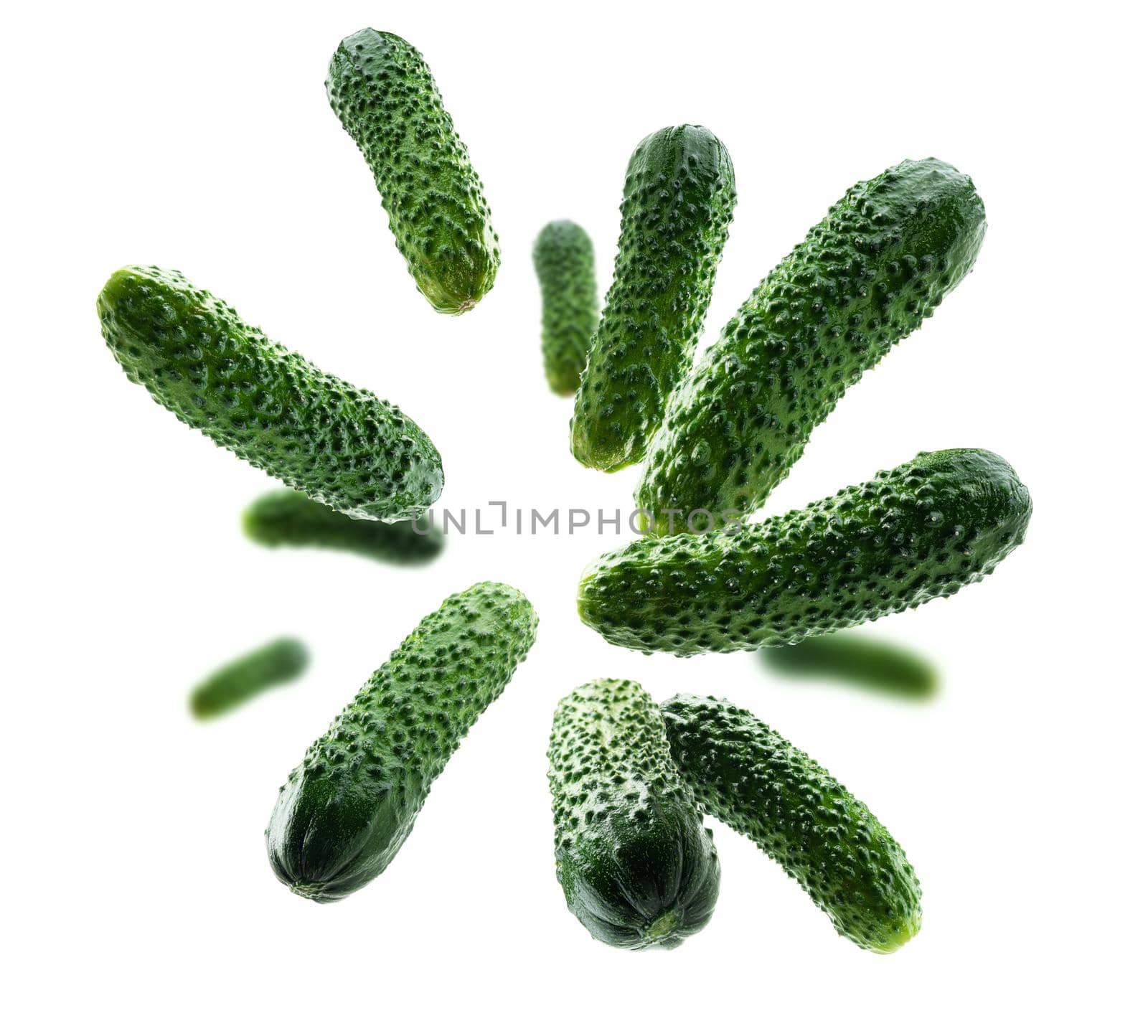 Green cucumbers levitate on a white background.