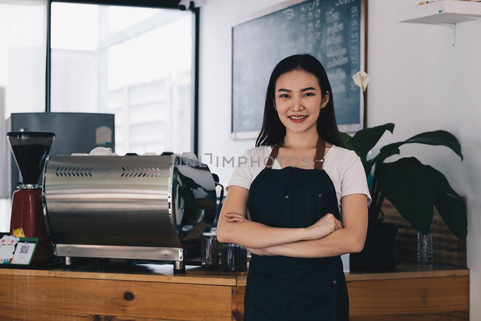 At her cafe, the business owner or barista is taking orders from customers