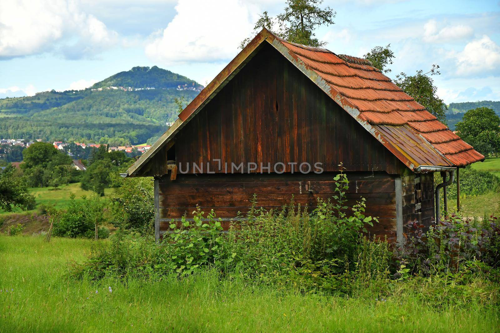 old barn with a hill in the background