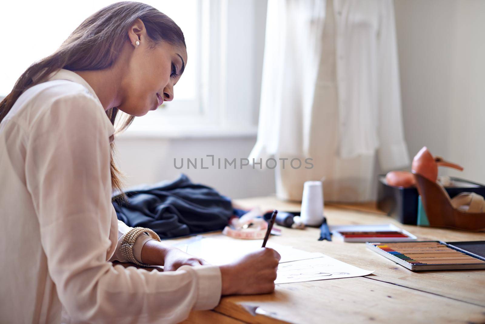 Coming up with new style trends. A fashion designer drawing sketches in her office. by YuriArcurs