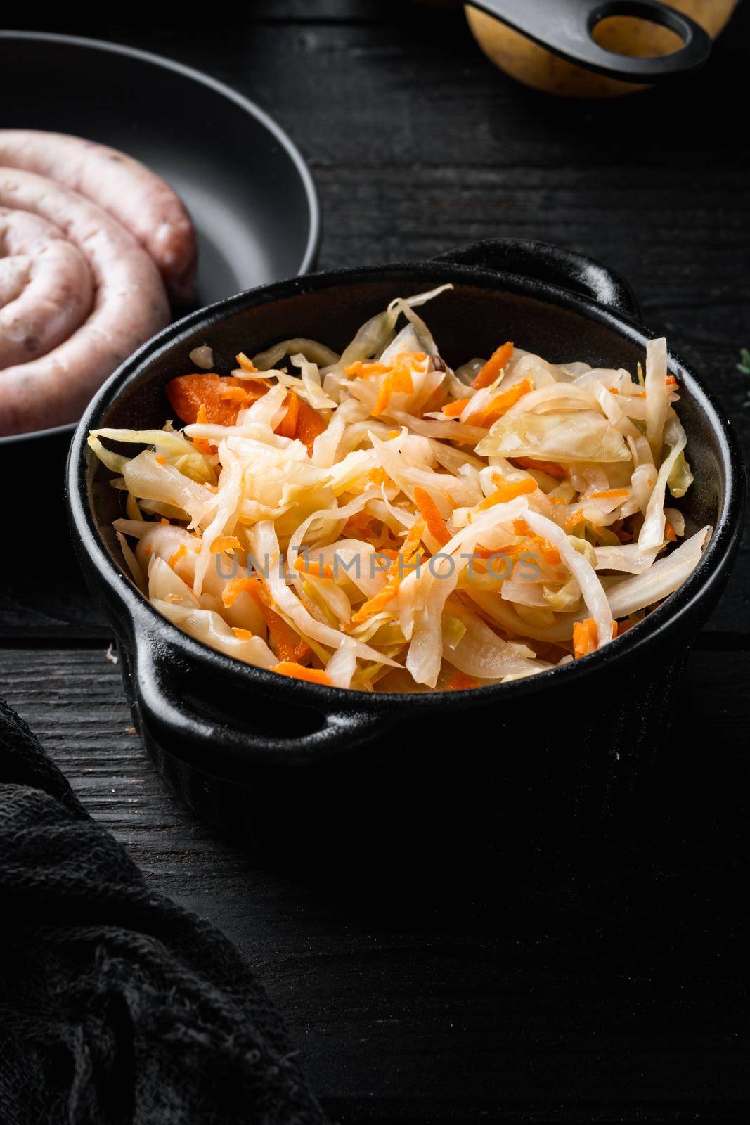 Sauerkraut preserving, on black wooden table background by Ilianesolenyi