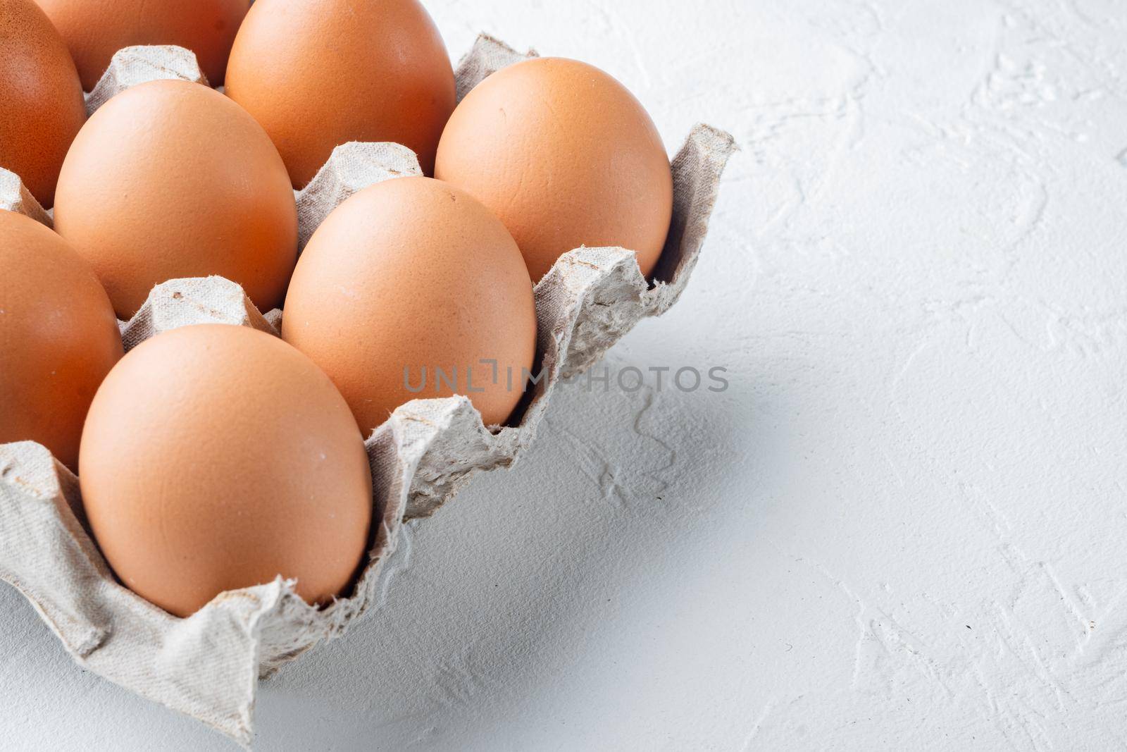 Fresh eggs on paper egg box set, on white background , with space for text copyspace