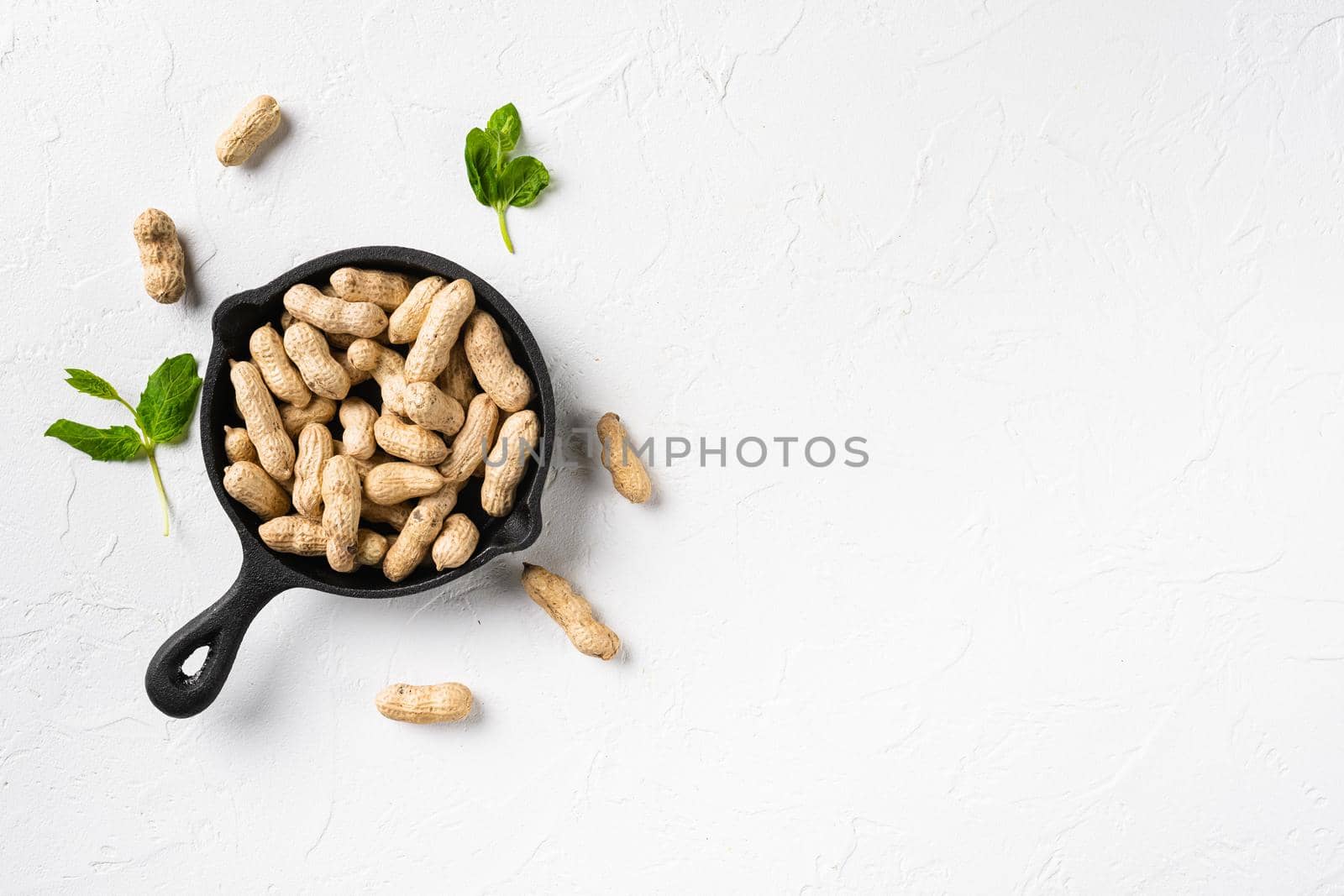 Dried peanuts. Tasty groundnuts set, on white stone table background, top view flat lay, with copy space for text