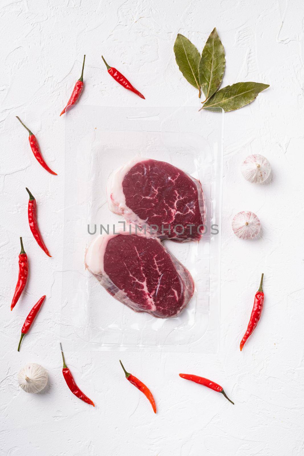 Packed pieces beef meat, on white stone table background, top view flat lay by Ilianesolenyi