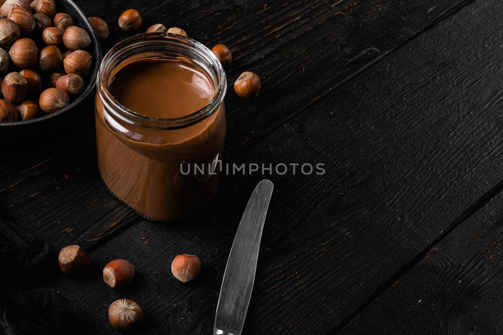 Sweet hazelnut spread set, on black wooden table background, with copy space for text