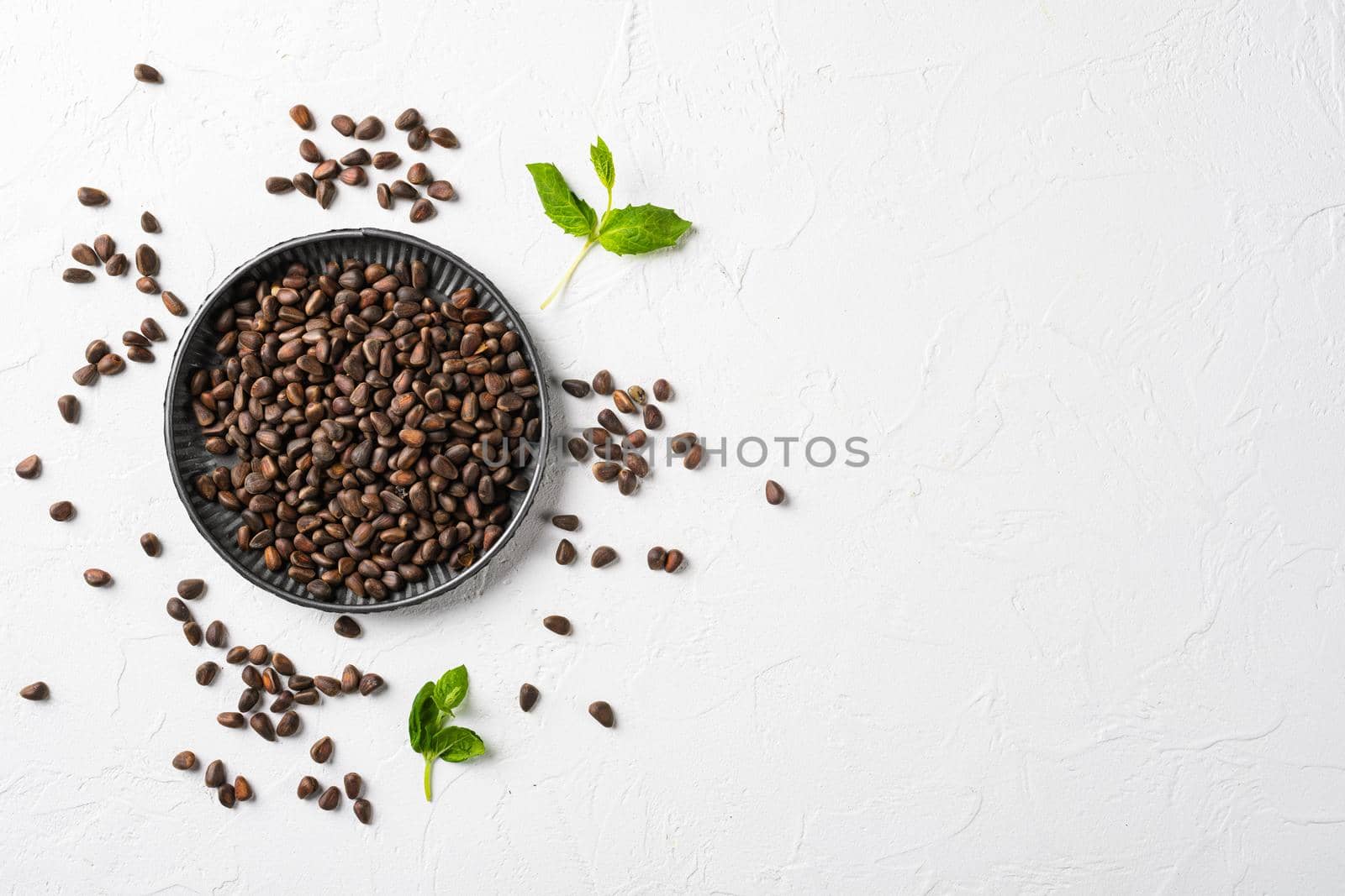 Pine wild organic nut set, on white stone table background, top view flat lay, with copy space for text