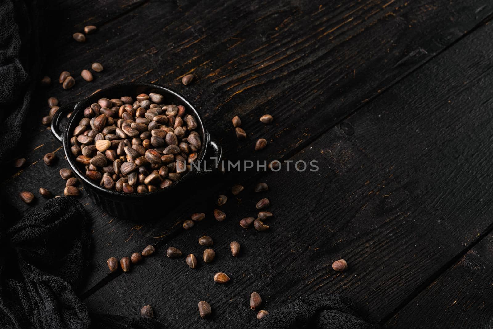 Pine nuts set, on black wooden table background, with copy space for text