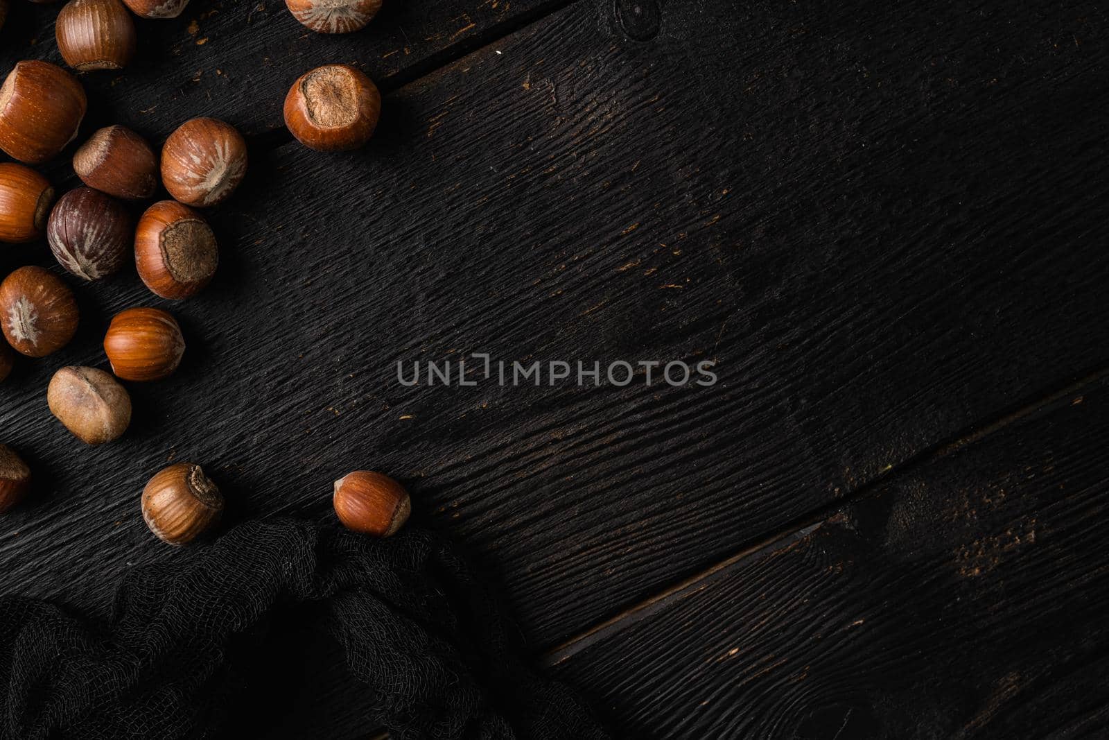 Hazelnut nut health organic brown filbert set, on black wooden table background, top view flat lay, with copy space for text