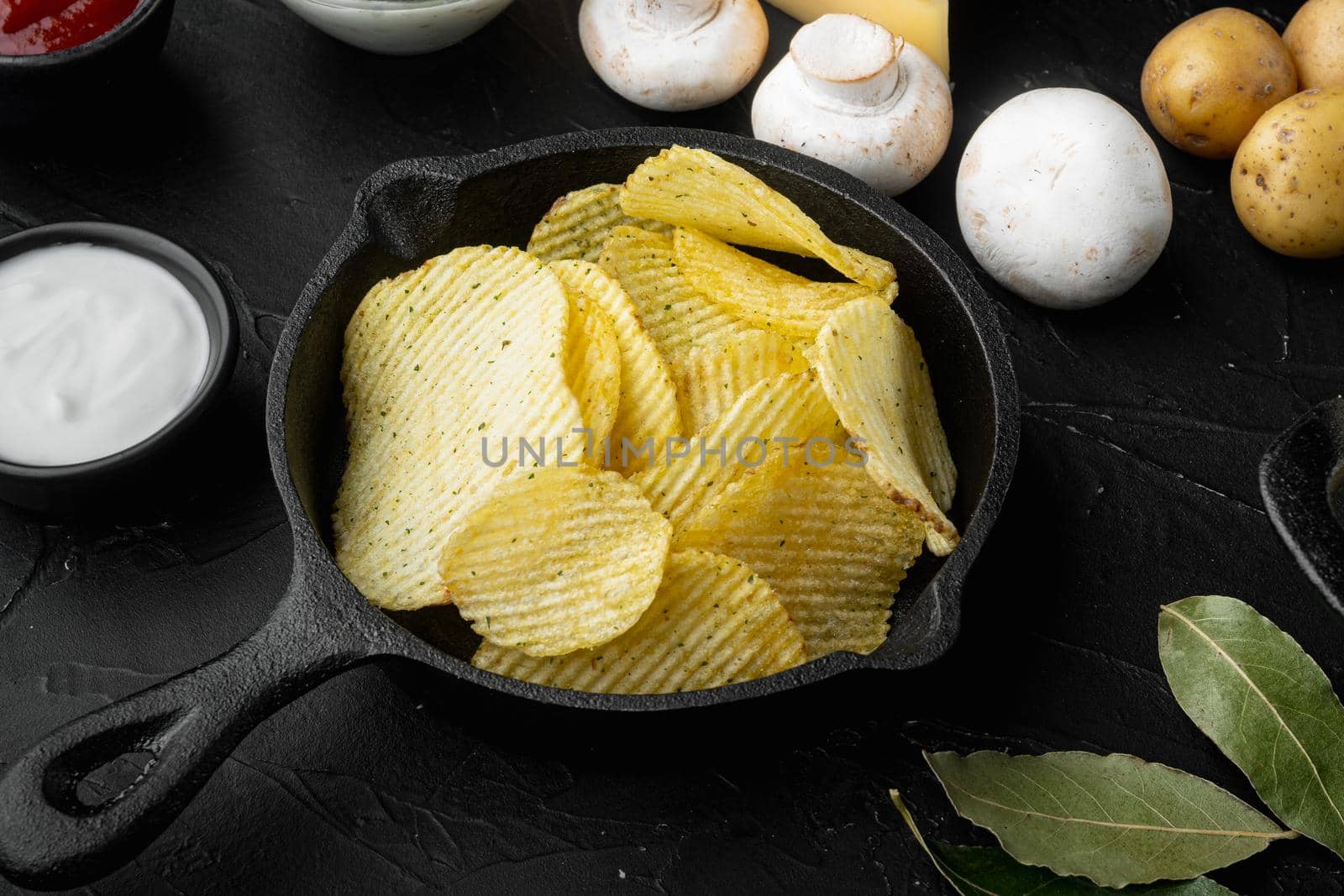 Home made potato chips set, on black stone background