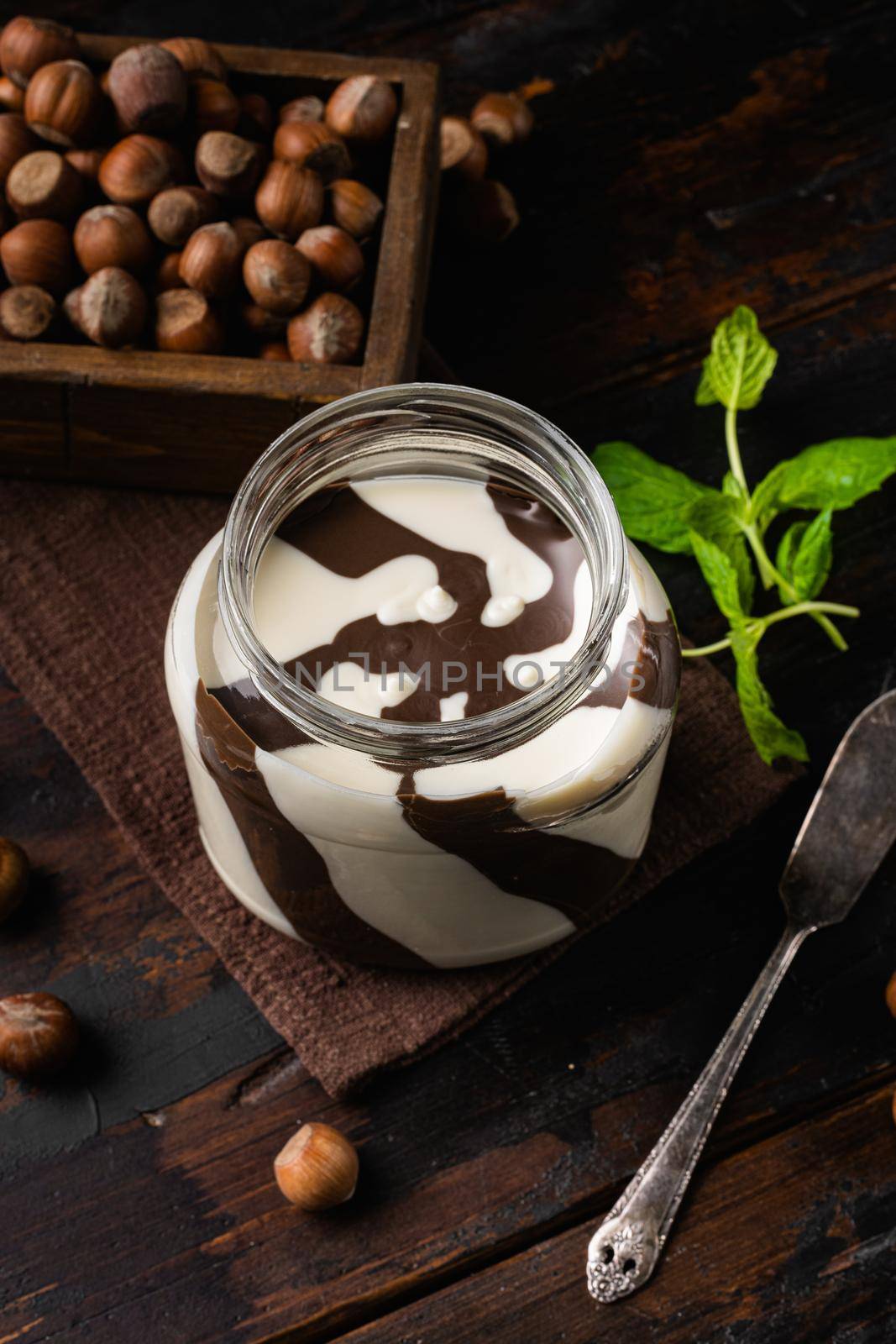 Chocolate hazelnut in jar with nuts set, on old dark wooden table background