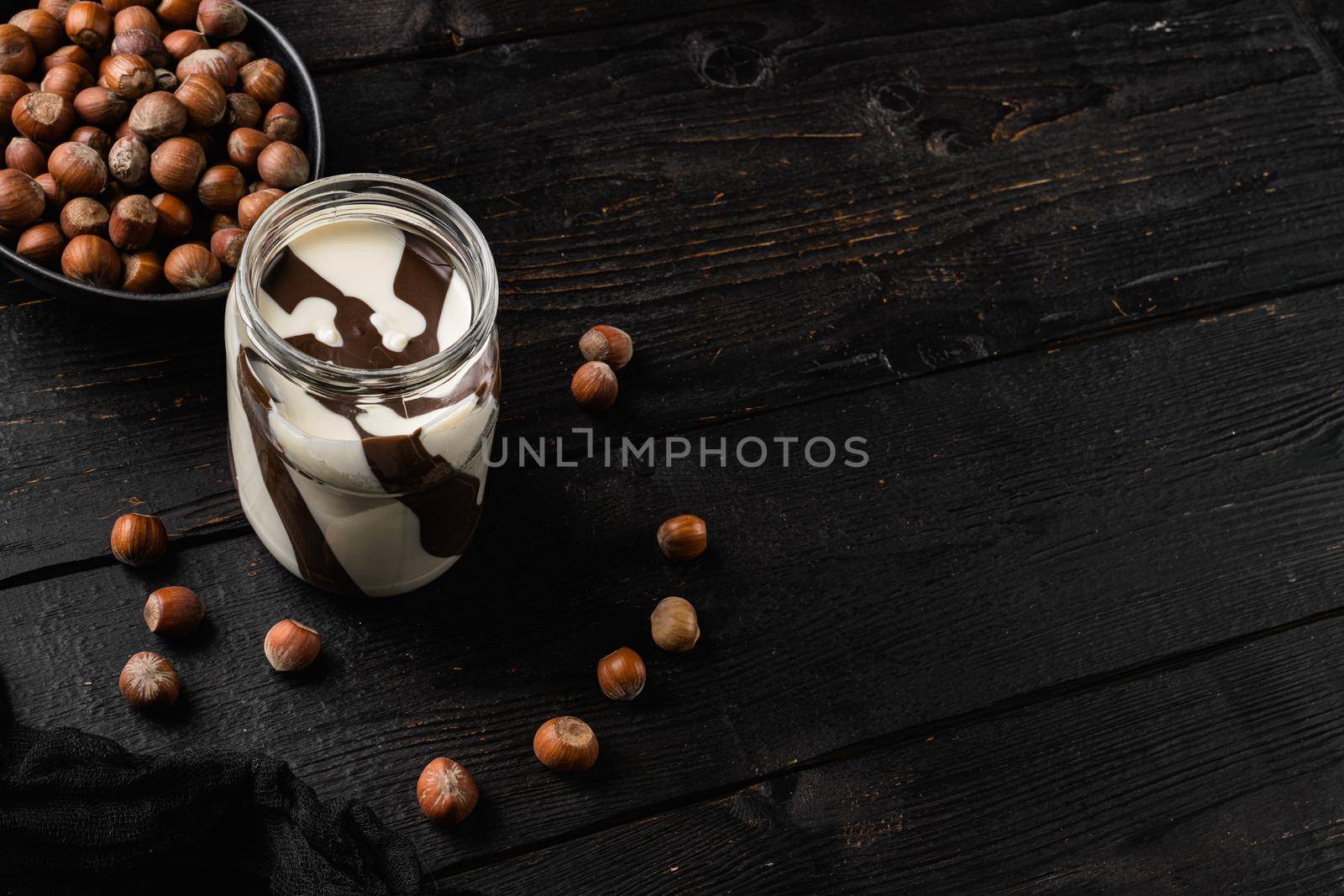 Sweet hazelnut spread set, on black wooden table background, with copy space for text