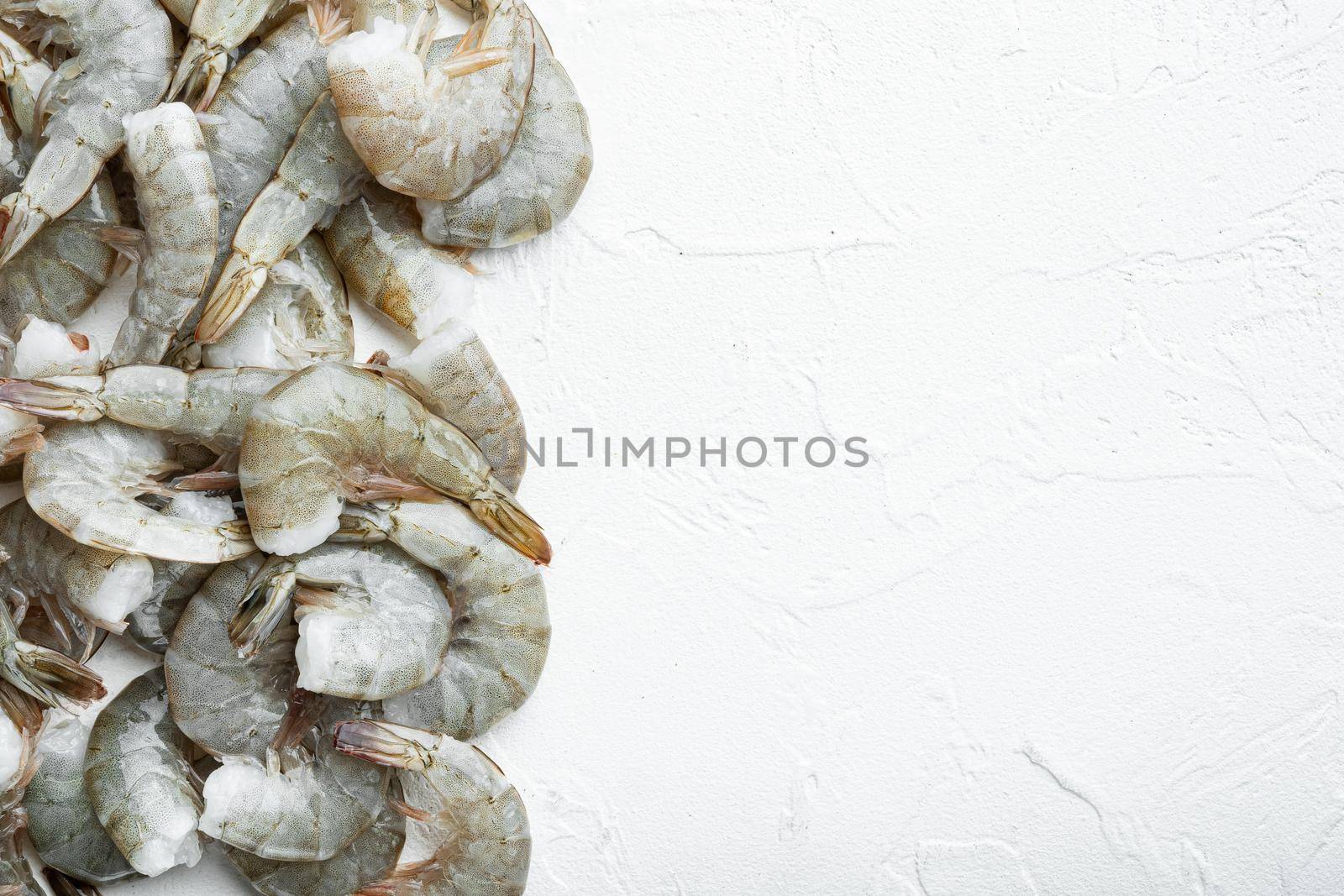 Raw fresh uncooked prawns shrimps set, on white stone surface, top view flat lay, with copy space for text