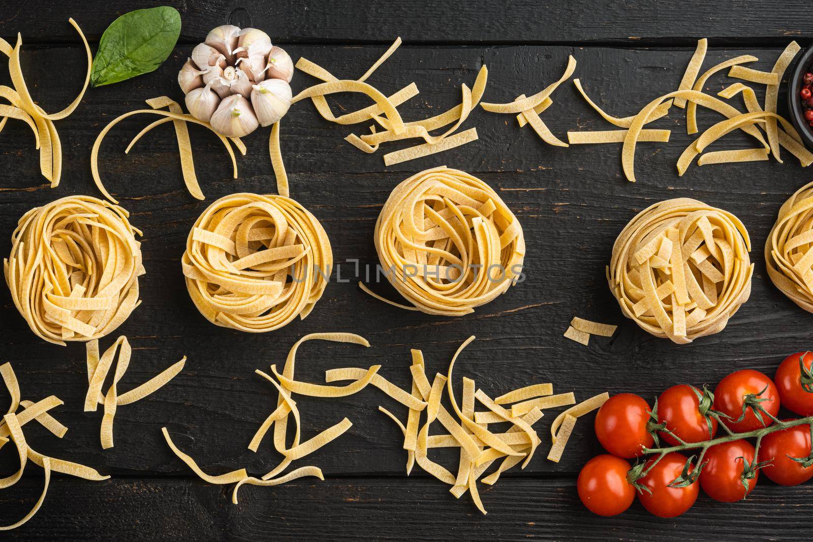 Fettuccine Tagliatelle pasta Italian food ingredients set, on black wooden table background, top view flat lay