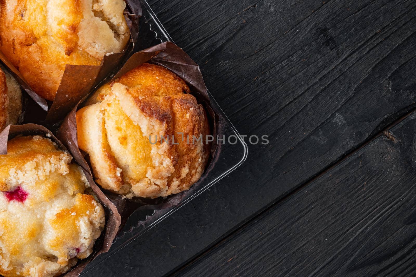 Delicious tasty muffin, on black wooden table background, top view flat lay with copy space for text