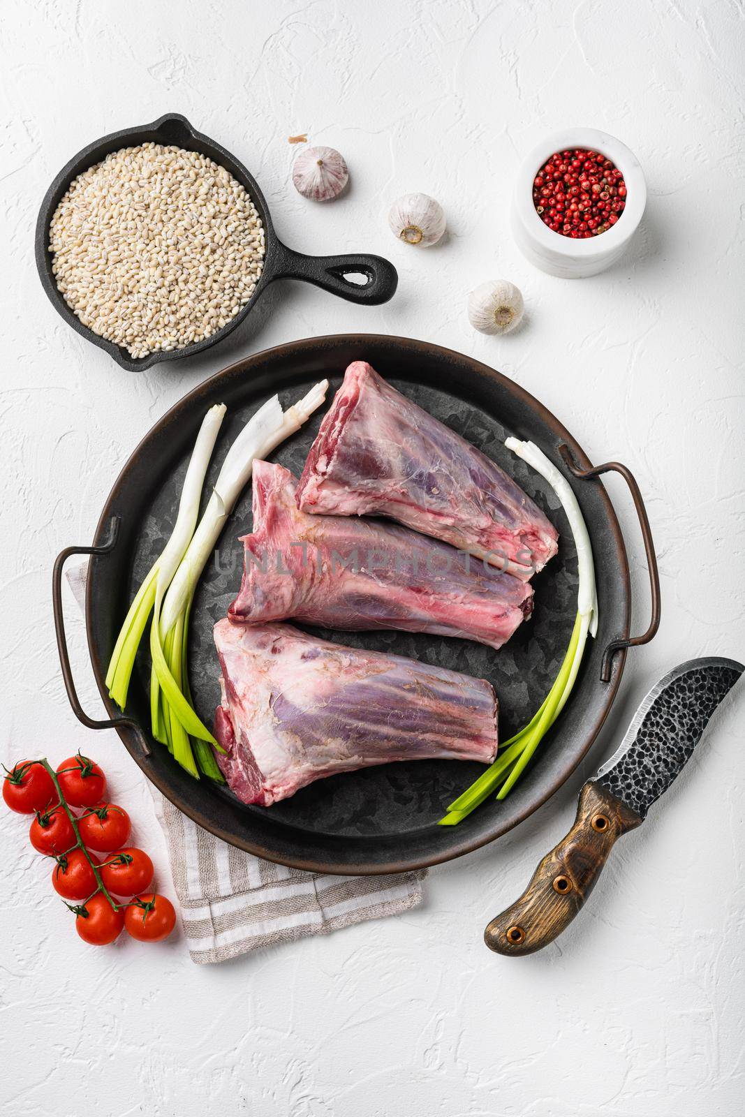Raw lamb shanks meat, on white stone table background, top view flat lay by Ilianesolenyi