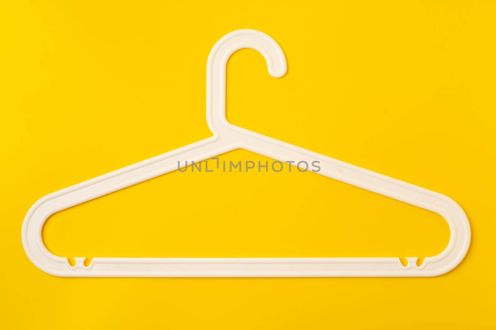 Hanger on colored paper background. Minimalistic fashion concept. Top view