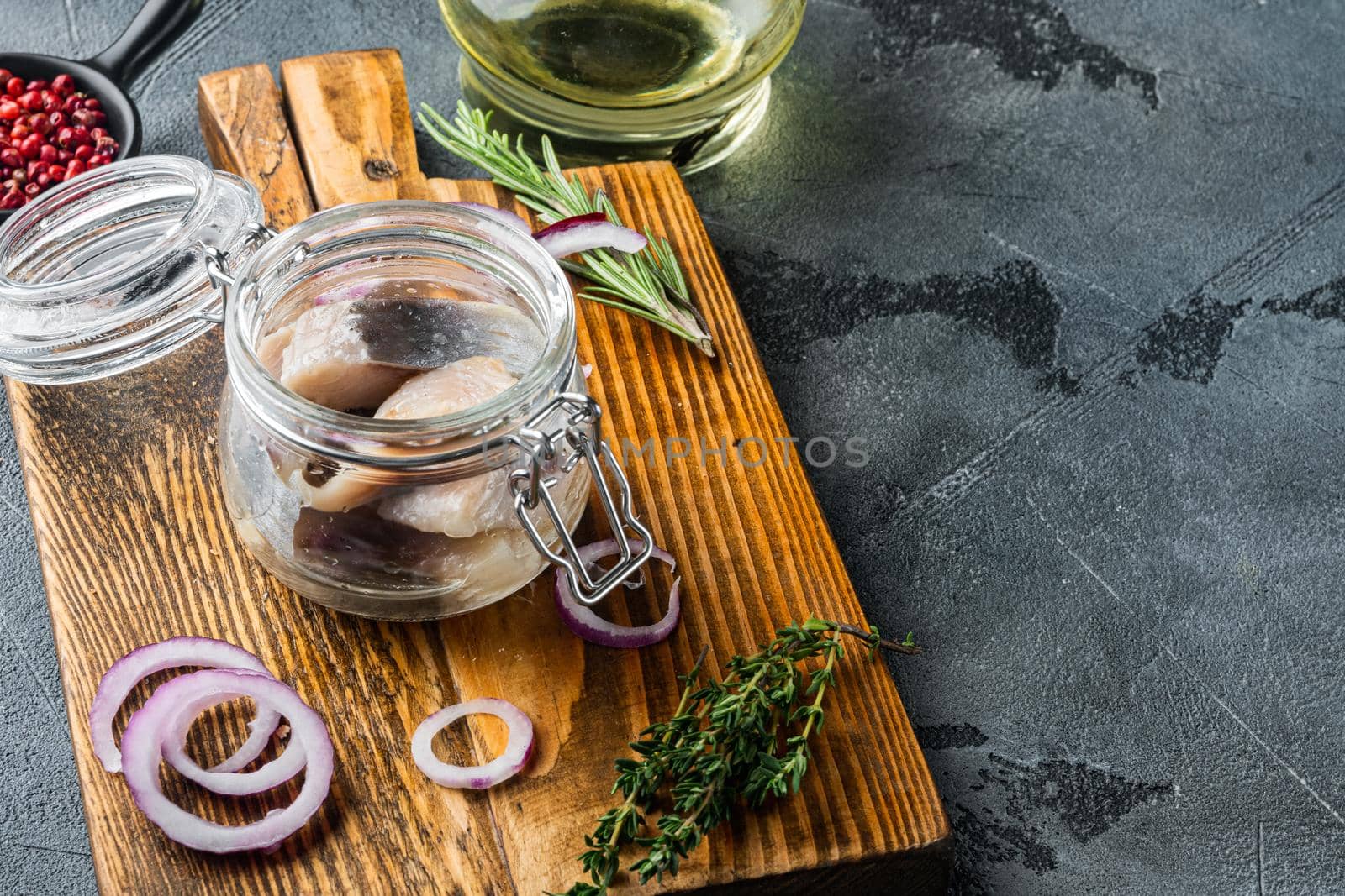 Pickled herring in oil, on gray background with copy space for text