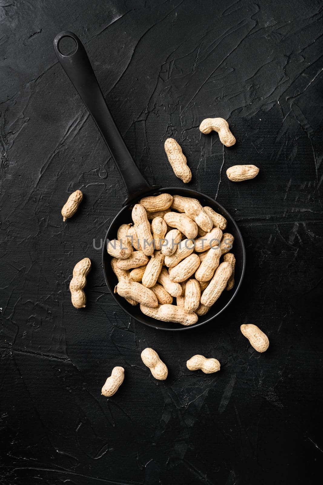 Whole peanut nuts, on black dark stone table background, top view flat lay by Ilianesolenyi