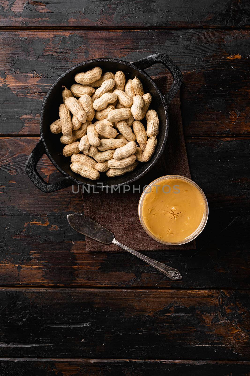 Creamy and smooth peanut butter in jar, on old dark wooden table background, top view flat lay, with copy space for text by Ilianesolenyi