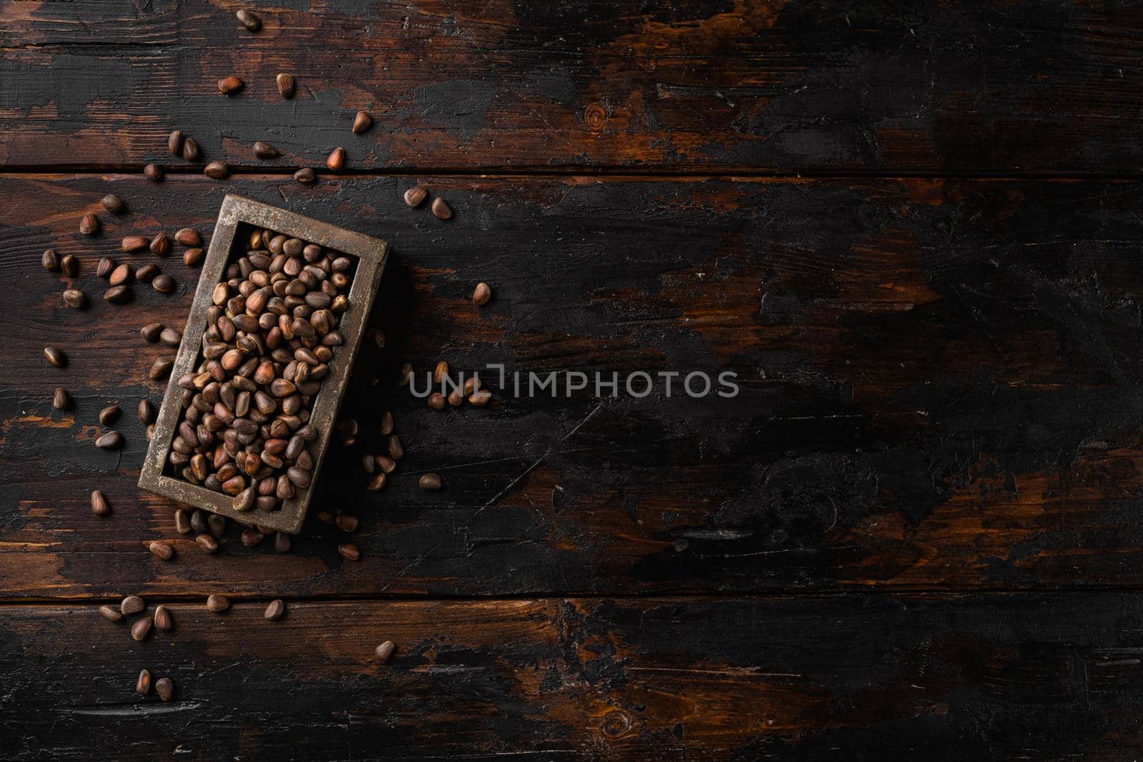 Cedar wild organic nut set, on old dark wooden table background, top view flat lay, with copy space for text