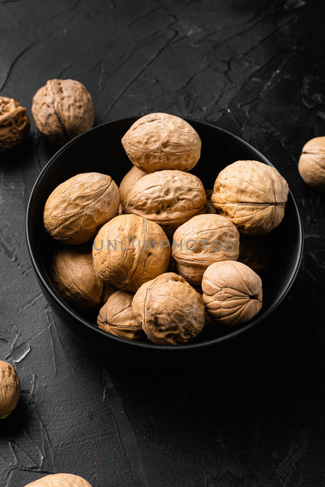 Natural walnut , on black dark stone table background by Ilianesolenyi