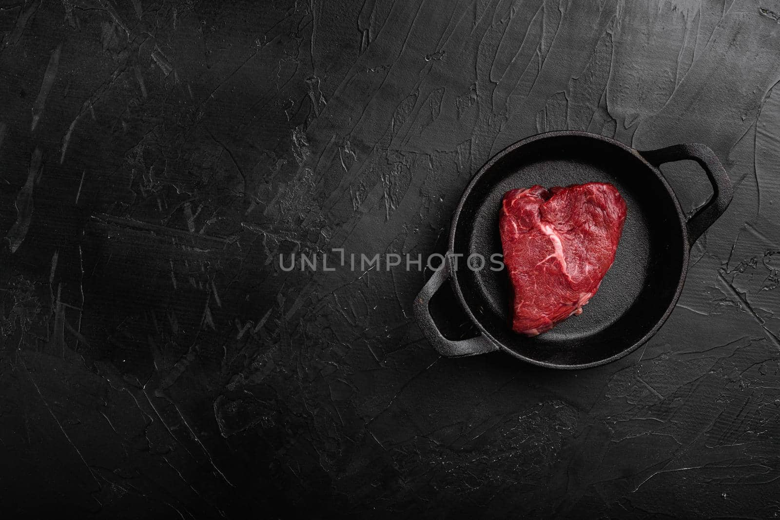 Raw seasoned rump steaks beef meat, on black dark stone table background, top view flat lay, with copy space for text by Ilianesolenyi