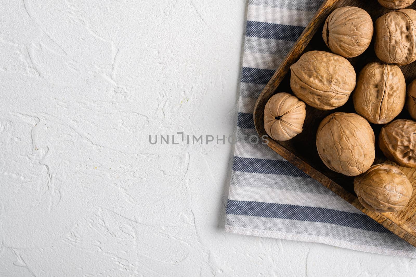 Walnuts with shells set, on white stone table background, top view flat lay, with copy space for text