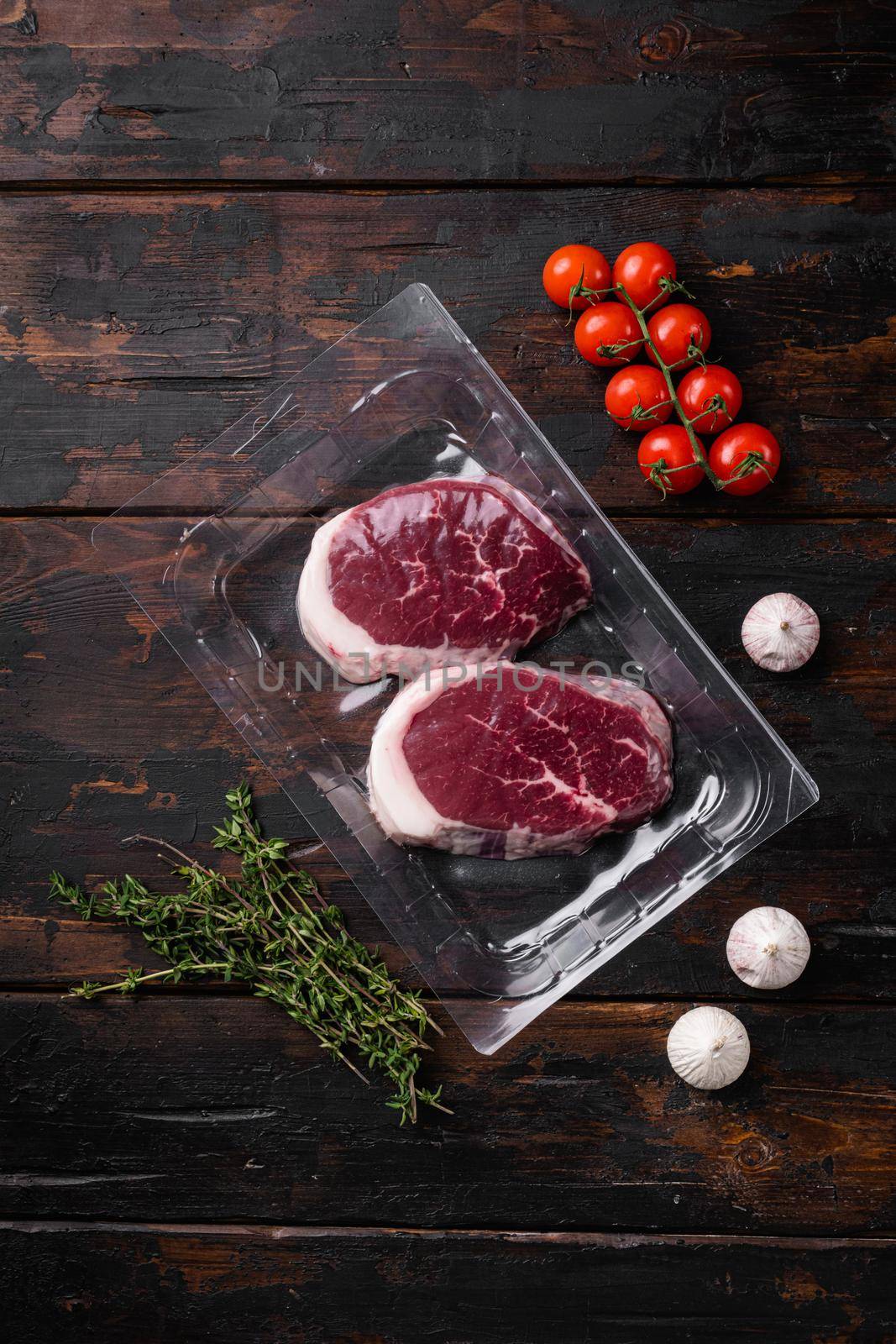 Packed pieces beef meat set, on old dark wooden table background, top view flat lay